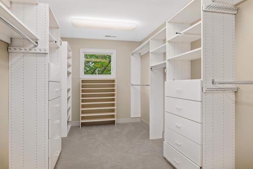 Enormous primary suite closet with a window