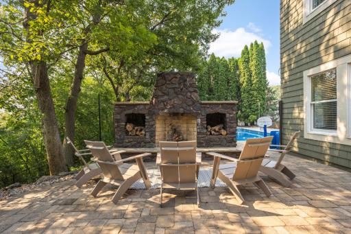 Outdoor fireplace is right off the lower level, family room, and next to the pool