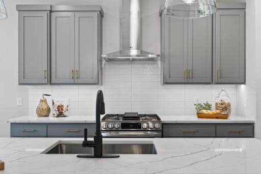 Quartz countertops complimented by timeless tile backsplash.