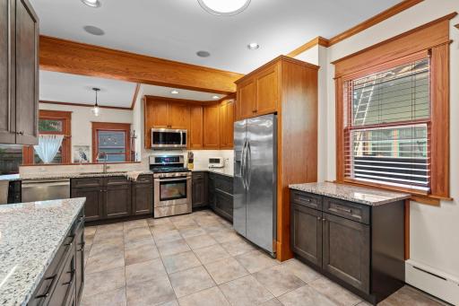 The gourmet kitchen is a chef's dream with granite counters, a breakfast bar, ample cabinet space, and newer stainless steel appliances.