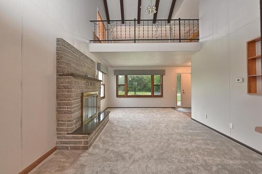 LIVING ROOM HAS WOOD BURNING FIRPLACE AND LARGE FRONT WINDOWS.