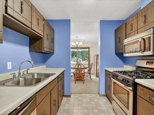 Functional galley-style kitchen with ample cabinetry and counter space, opening directly to the dining area and deck for convenient entertaining.