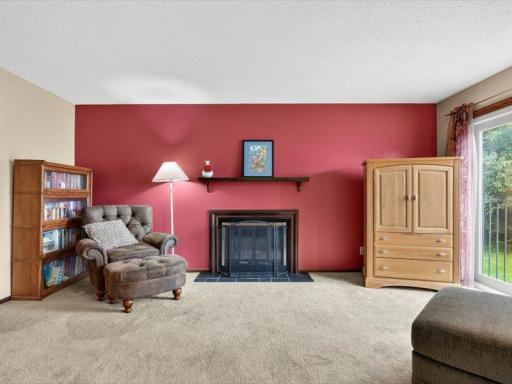 Spacious living room featuring a bold accent wall, wood-burning fireplace, and sliding glass doors that fill the space with natural light.