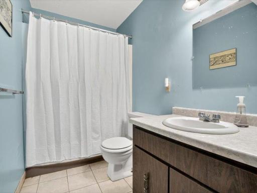 Convenient full bath with tile flooring, vanity, and a tub/shower combo.