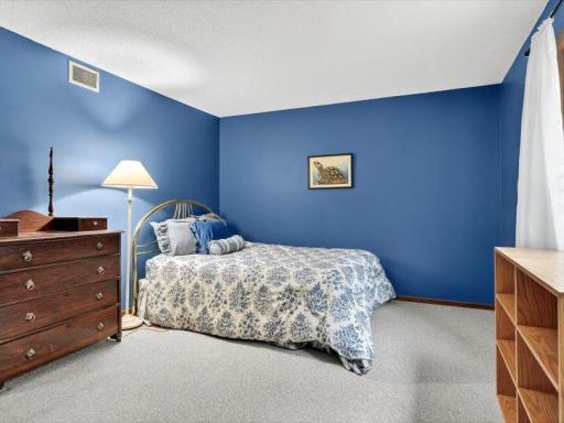Spacious 2nd bedroom with large window for natural light, painted in a bold blue tone for a vibrant feel.