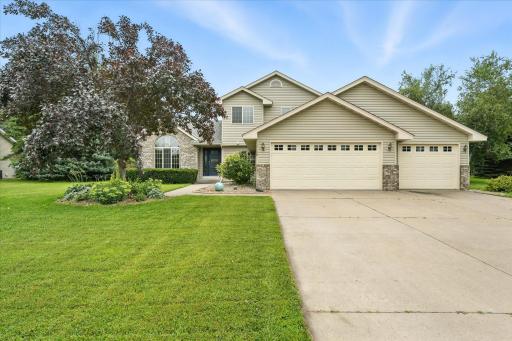 Beautiful modified two-story home with timeless brick and vinyl siding exterior, complemented by a three-car garage, concrete driveway and well-maintained lawn. Mature trees and landscaping add both shade and privacy to this inviting property.