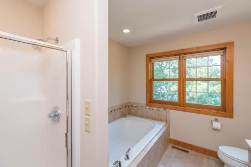 Upper Level Bathroom has a ceramic surrounded Jacuzzi Tub and a Shower