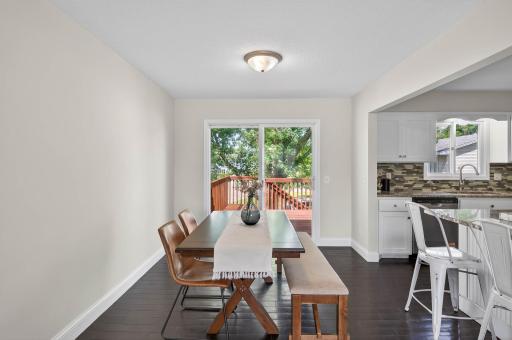 Dining area leads to newly stained deck and backyard views.