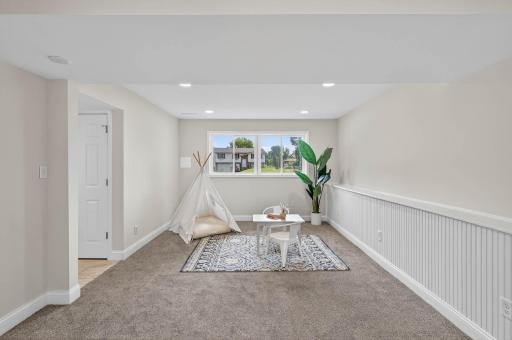 Lower level family room with new carpet offers flexible layout options.