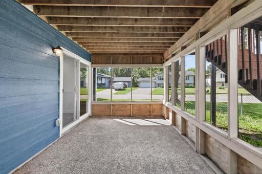 Lower level screened porch offers space for outdoor dining and access to the backyard.