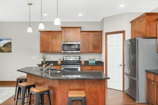 Beautiful kitchen with black granite countertops on the perimeter and island, stainless steel appliances, soft close drawers and a walk-in pantry! The 4 bar/counter stools can be included with the sale of the house.