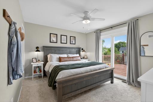 Primary bedroom has a walk-in closet and patio door that opens to the expansive deck