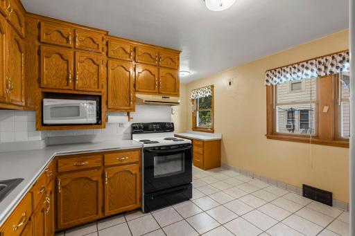 Generous counter space and timeless ceramic tile floors enhance the kitchen.
