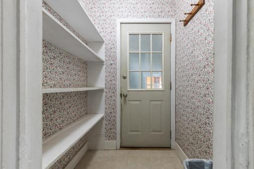 Garage entryway features shelving which could dual purpose as pantry storage
