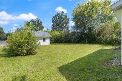 A peaceful backyard surrounded by shrubs and trees for naturally provided privacy!