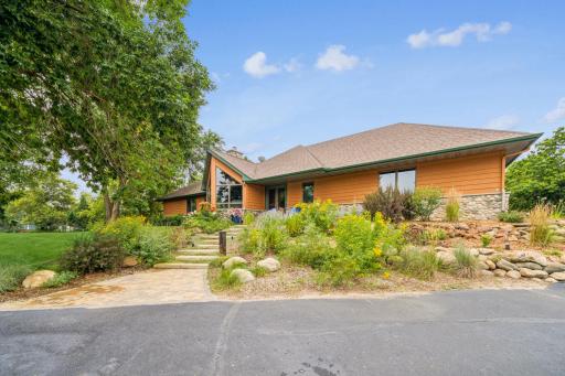 Lush landscaping with well established perennials lure you to the inviting front entry.