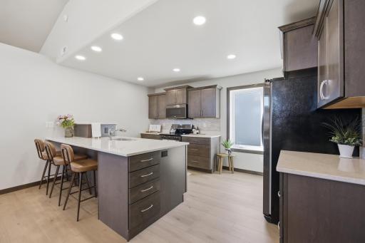 Kitchen with Quartz, Tile backsplash, pantry and a raised dishwasher. Room to sit at the island for a quick meal, or for serving.