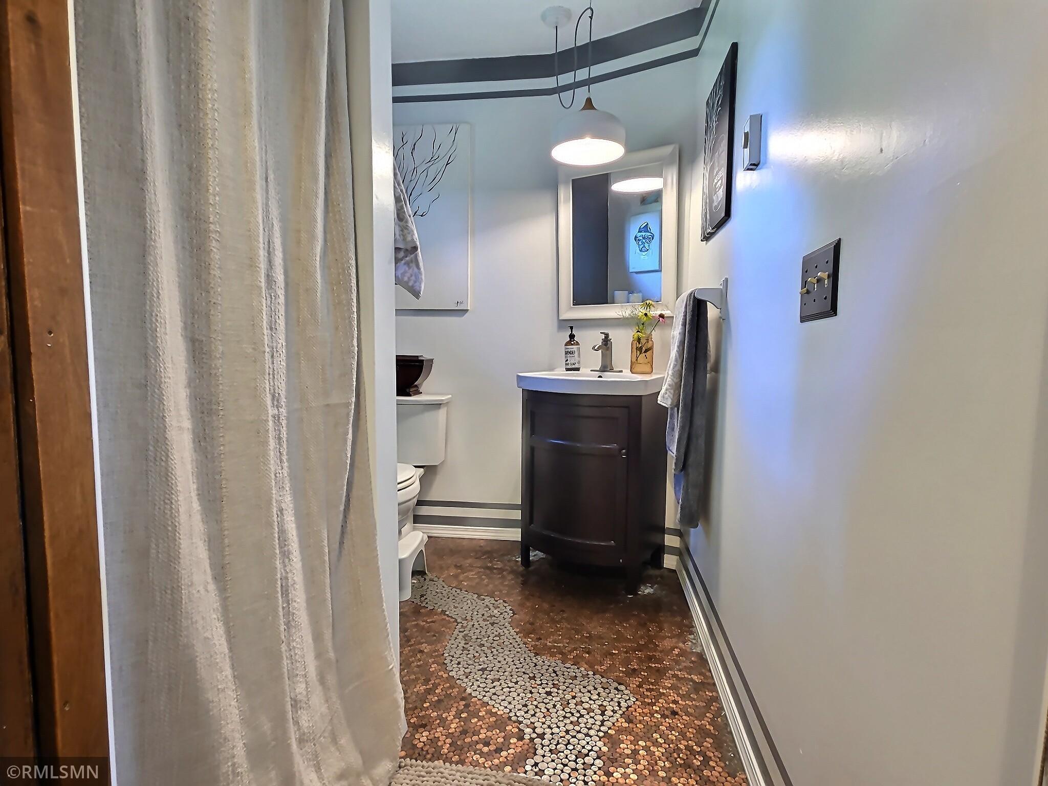 Main floor 3/4 bath has a cool epoxied floor made out of change.