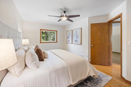 The spacious main level bedroom features a large window and ceiling fan