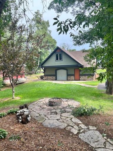 Stone walkway and firepit area between the house and the garage