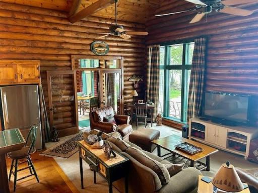 The great room with nice wall for tv, and large windows on both sides with lake views. Door goes out to 4 season sun room