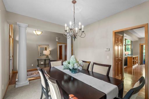 The formal dining room offers an elegant setting with chandelier, decorative pillars, and a large picture window.