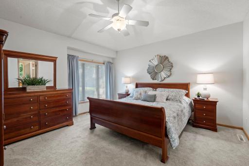 The main-level primary suite is a private retreat, entered through French doors and featuring a 10-foot tray ceiling, new carpet, and a walk-in closet.