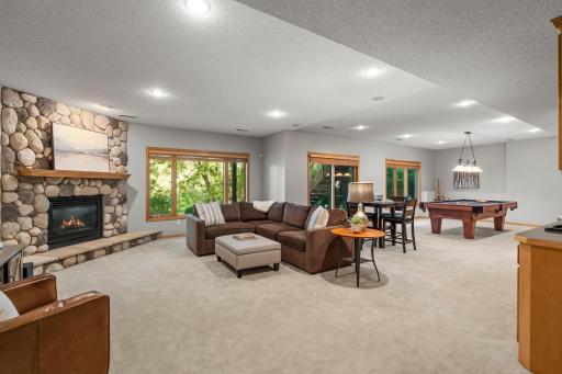 The lower level extends living space with a family room anchored by a stone fireplace and walkout to a 31x18 patio, along with abundant storage.
