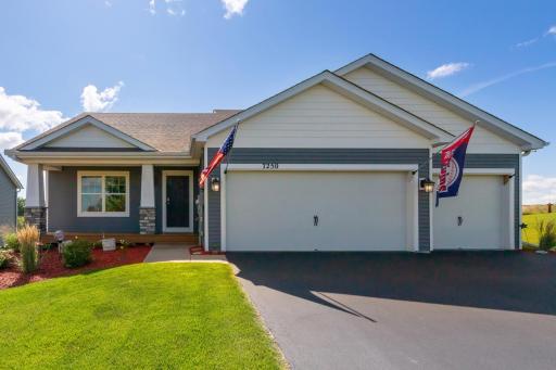 Bright and inviting exterior showcasing a 3-car garage, updated siding, and landscaped front yard.