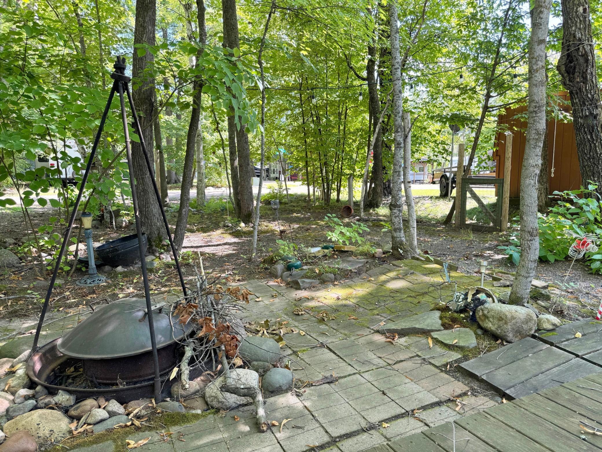 Another angle of the firepit with the pleasant tree coverage beyond.