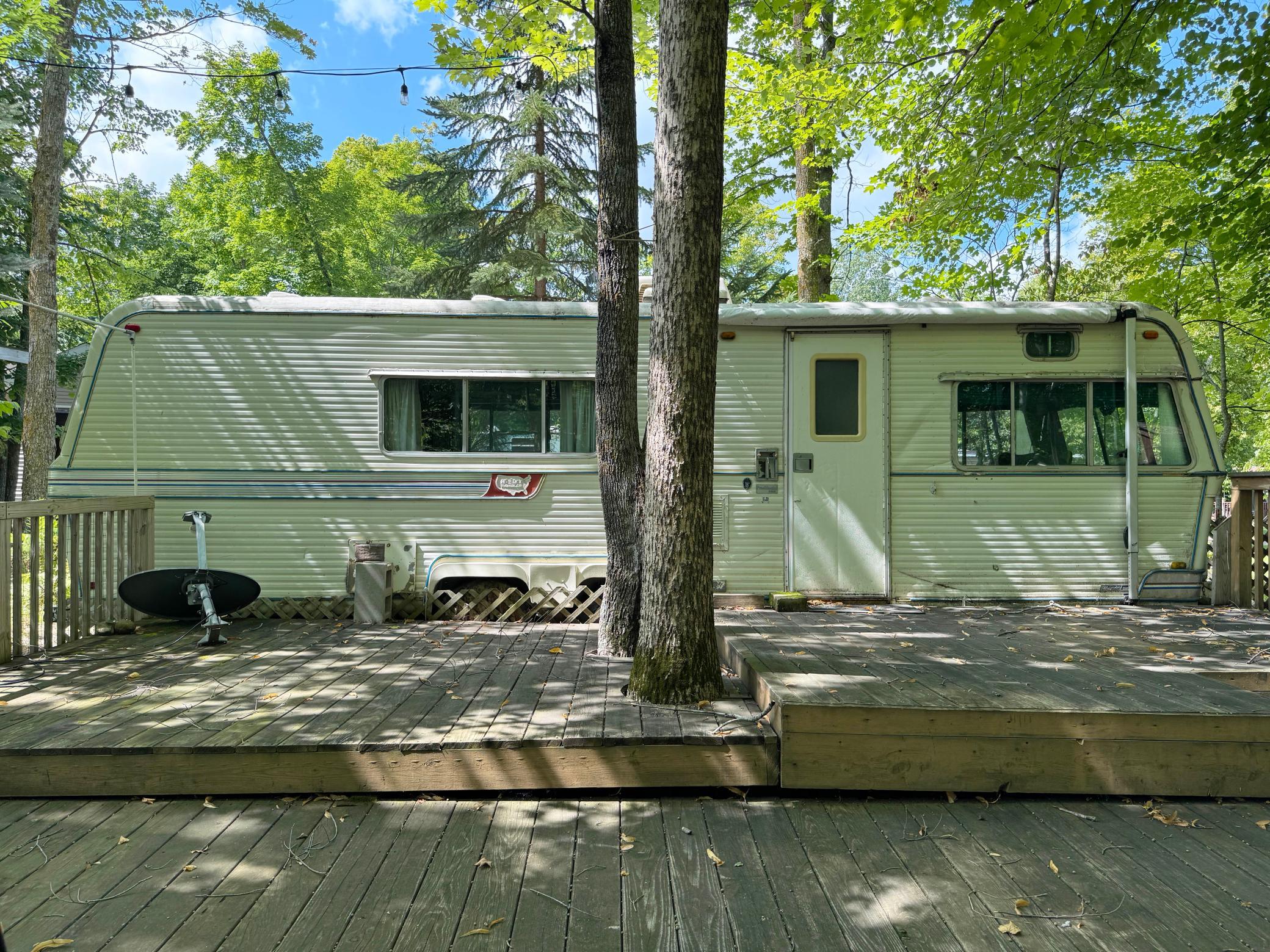 Looking at the camper from the edge of the deck. Bring in your own rig and enjoy this getaway lot!