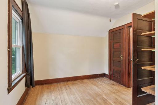 Another photo of this bedroom shows the closet and wall shelving.