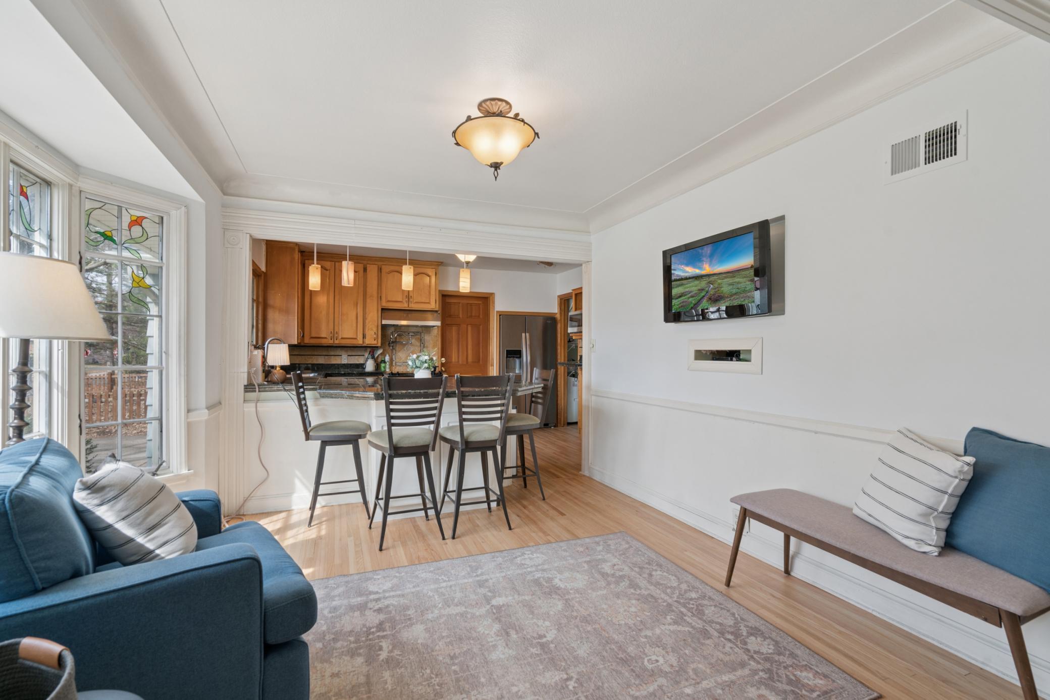 Open kitchen with breakfast bar seating, and adjacent dining space filled with natural light.