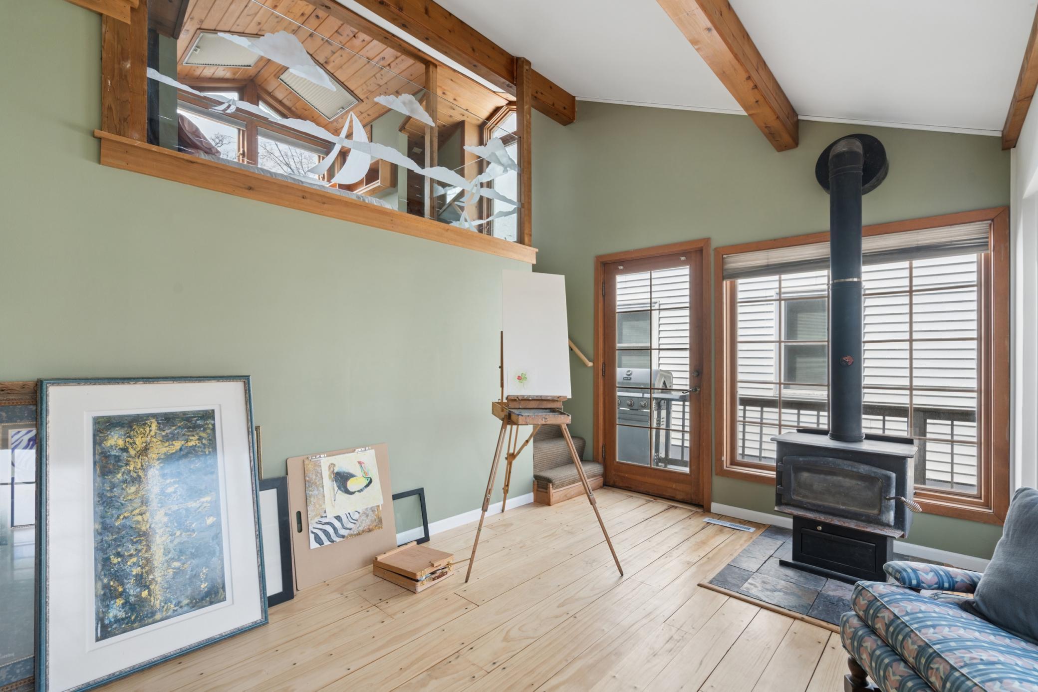 Upper level loft space with vaulted ceilings and exposed beams, perfect for a 3rd bedroom, studio, or home office.