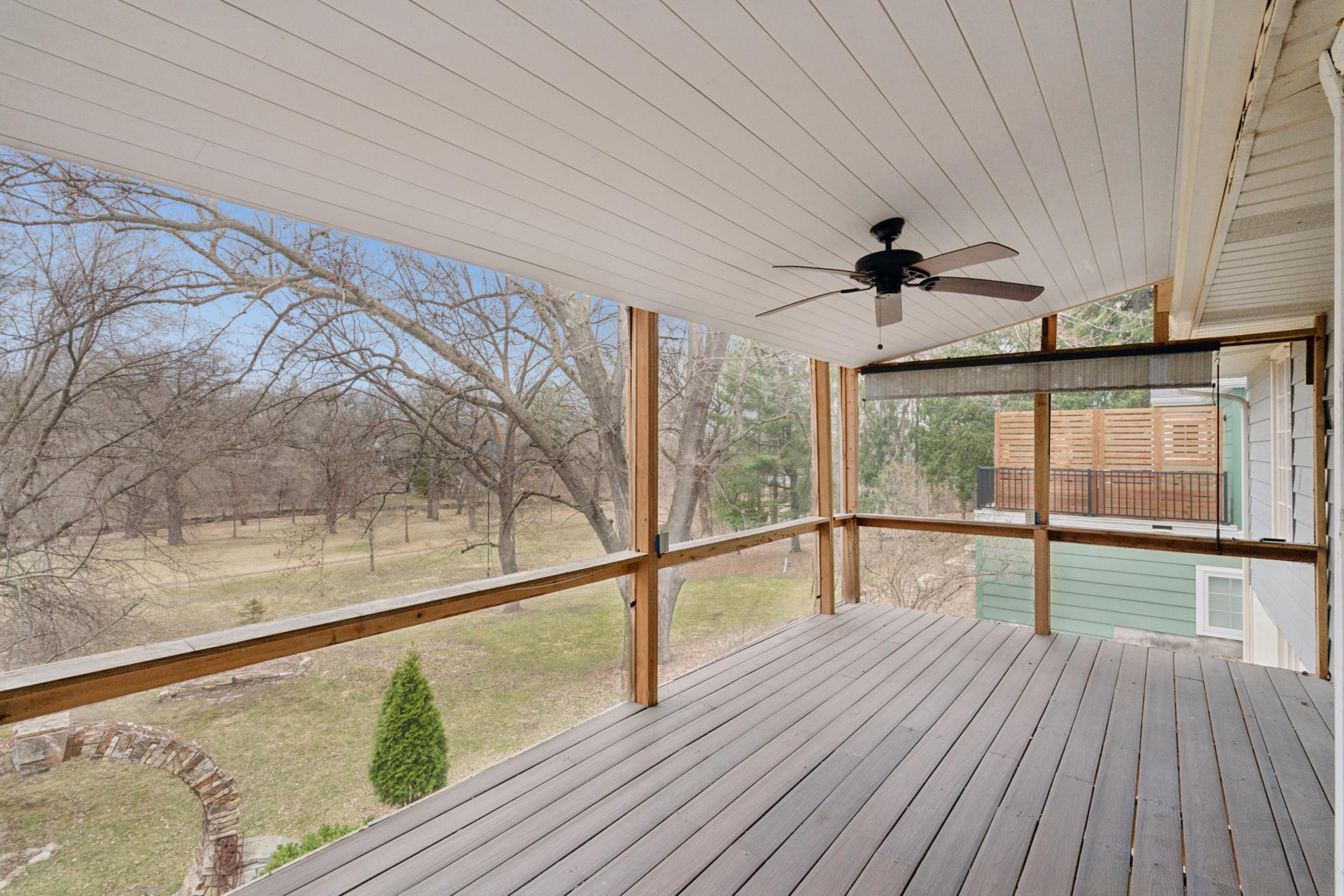 Three season screened porch with elevated views of Minnehaha Creek and park board land, ideal for relaxing or entertaining.