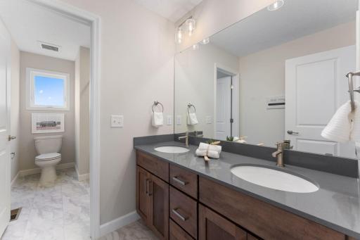 Upper level hall bathroom with double sinks. Door separates tub/toilet from sink area.