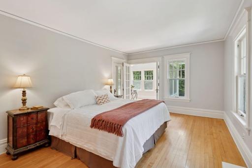 Spacious primary bedroom opens to a 2nd floor sunroom through French doors