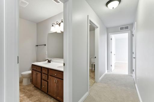 Looking down the hall to the primary suite you'll see the full bath and laundry room