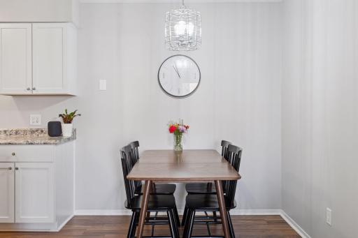 Spacious dinette with updated flooring opens to kitchen and living room.