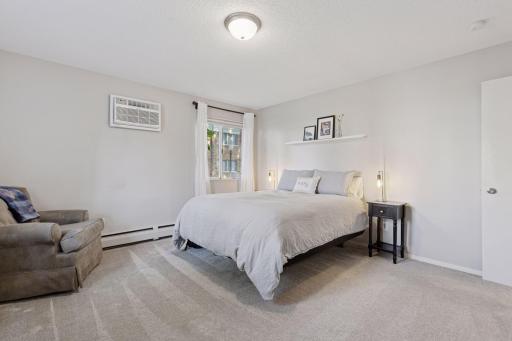 Spacious and pristine owners bedroom with plush carpeting, inviting soft neutral colors, 2 windows, great closet space, and brand new A/C.