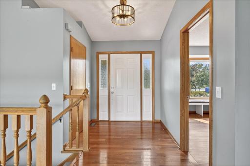 The large foyer greets you with a coat storage closet, a dual sidelight front door, and 3/4" solid oak hardwood floors.