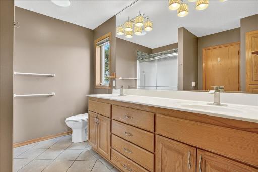 The primary bath features a walk in shower, tile floors, a dual sink vanity, modern lighting and an exhaust fan with a built-in humidity sensor and bluetooth speaker!