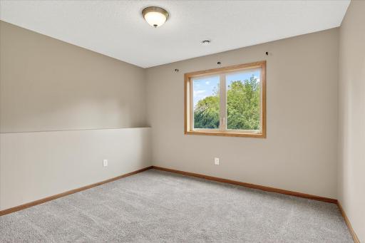 Here is one of two lower level bedrooms, which both feature modern & neutral carpet & paint.