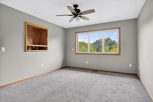 The main level primary bedroom is 16 x 12 and features a ceiling fan, huge windows, neutral & modern paint, and updated AND upgraded modern & neutral carpet.