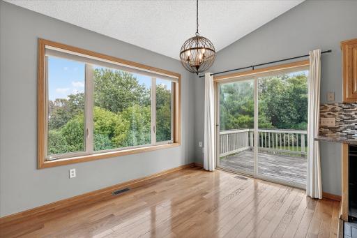 The dining room features a modern light fixture, and another huge window overlooking the private back yard.
