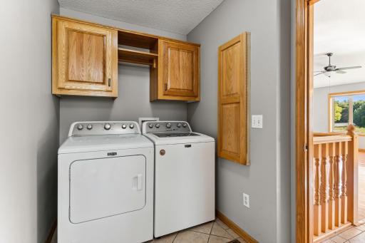 The main level laundry room features storage cabinetry, a built in ironing board and updated laundry machines, which are included in the sale!