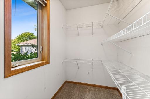 This walk-in closet has great organizers and an operable window too.