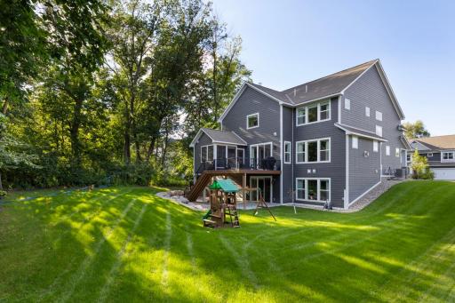 Professionally landscaped yard with mature trees and lush greenery, creating a serene backdrop