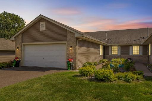 The inviting front walk is framed by perennials and an attached 2-car garage.