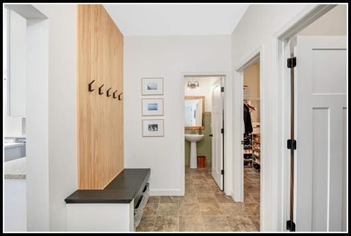 Mudroom off the garage entry includes a custom-designed coat hook wall, a walk-in coat closet, and separate walk-in pantry